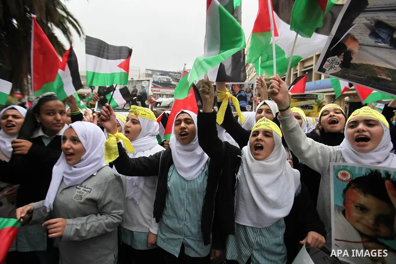 Palestinian students hold National flags during a protest to demand their rights, in the west Bank city of Nablus, on Oct. 29, 2015. Photo by Nedal Eshtayah