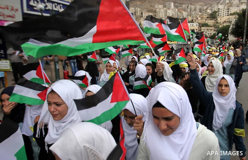Palestinian students hold National flags during a protest to demand their rights, in the west Bank city of Nablus, on Oct. 29, 2015. Photo by Nedal Eshtayah