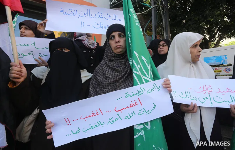 Palestinian women hold their national flag and banners during an anti-Israel protest in Gaza, on October 29, 2015. New knife attacks on Israelis in the West Bank left a soldier lightly injured, while two Palestinian assa...