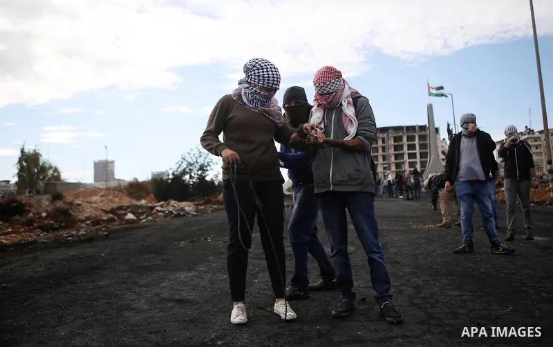 A female Palestinian protester uses a sling shot to hurl stones at Israeli troops during clashes near the Jewish settlement of Bet El, near the West Bank city of Ramallah, October 29, 2015. Israeli security forces shot d...