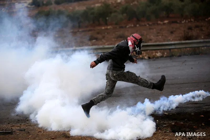 A Palestinian protester kicks back a tear gas canister fired by Israeli troops during clashes near the Jewish settlement of Bet El, near the West Bank city of Ramallah, October 29, 2015. Israeli security forces shot dead...