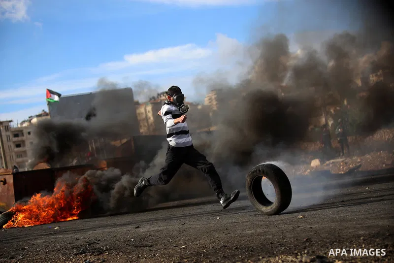 A Palestinian protester kicks a burning tyre during clashes with Israeli troops near the Jewish settlement of Bet El, near the West Bank city of Ramallah, October 29, 2015. Israeli security forces shot dead two Palestini...