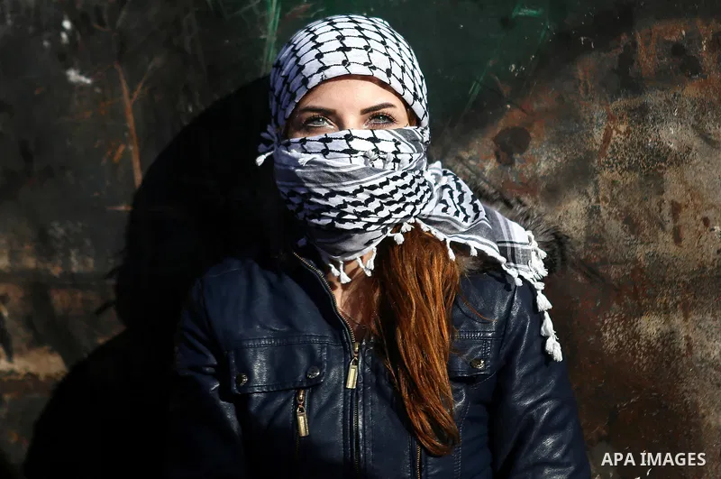 A female Palestinian protester takes a cover during clashes with Israeli troops near the Jewish settlement of Bet El, near the West Bank city of Ramallah, October 29, 2015. Israeli security forces shot dead two Palestini...