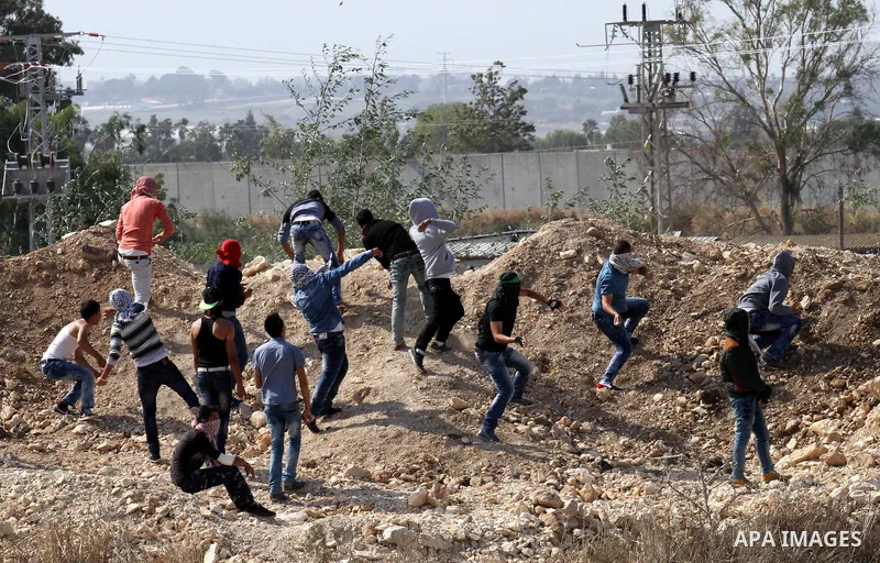 Palestinian protesters throw stones towards Israeli security forces during clashes near the Israeli controversial separation barrier, in the West Bank town of Tulkarm, November 3 , 2015. Meanwhile, Israeli forces early 0...