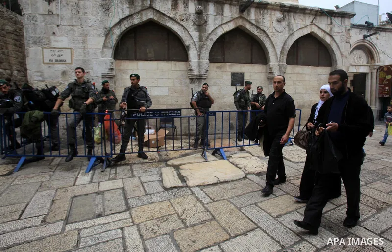 Palestinians walk past Israeli policemen as they stand guard in Jerusalem's old city following Friday prayers on November 6, 2015. The current wave of violence erupted in mid-September, fueled by rumors that Israel was t...
