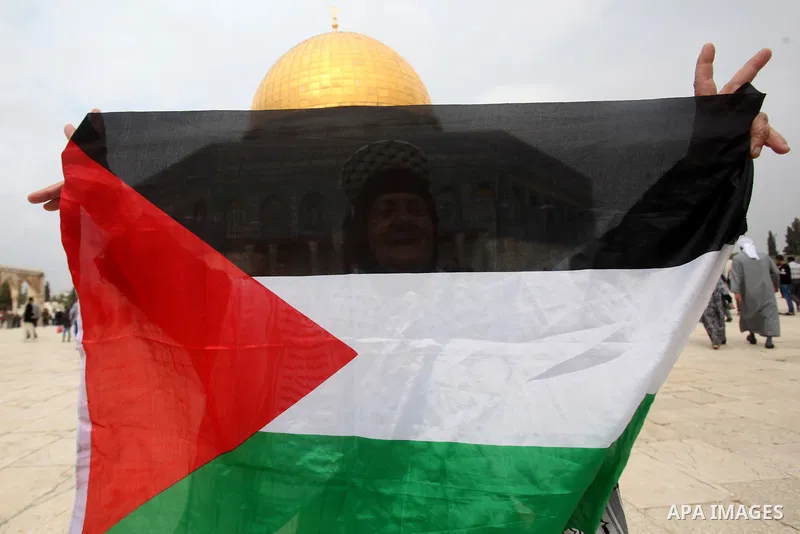 A Palestinian woman holds her national flag in front of the Dome of the Rock mosque, following the Friday prayers at al-Aqsa mosque compound in Jerusalem's old city on November 6, 2015. The current wave of violence erupt...