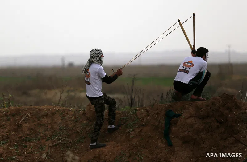 Palestinian protesters use a big sling shot to throw stones towards Israeli security forces during clashes near the border between Israel and eastern Gaza city, November 6, 2015. The current wave of violence erupted in m...