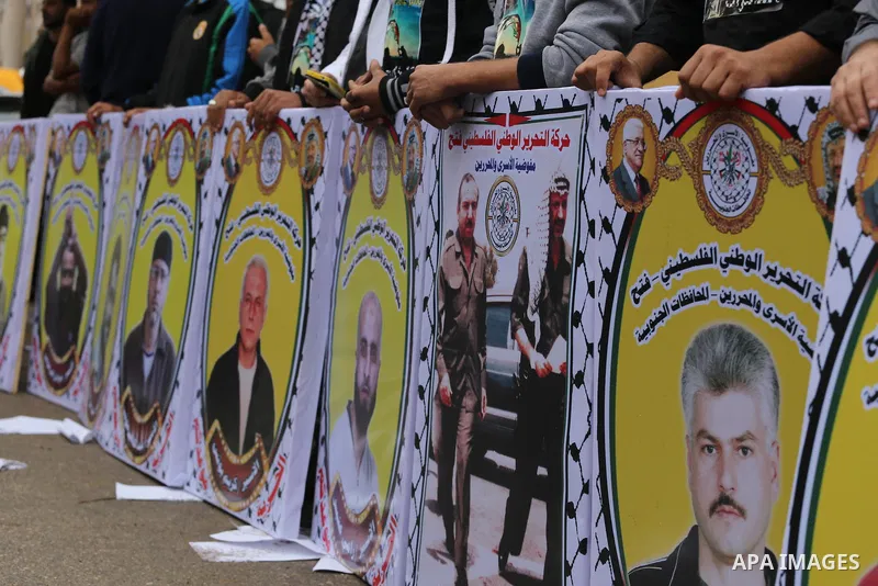 Palestinians hold banners during a rally marking the eleventh anniversary of late Palestinian leader, Yasser Arafat, in front of Red cross office, in Gaza city, on Nov. 09, 2015. Photo by Mohammed Asad