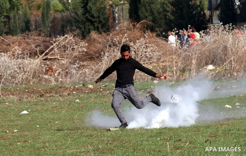 A Palestinian protester kicks back a tear gas canister during clashes with Israeli security forces in the West Bank city of Tulkarm, November 11, 2015. Some 61 Palestinians have been killed in Jerusalem and the West Bank...