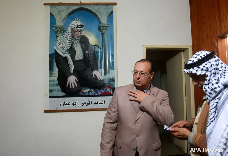 Palestinians stand in front of the picture of late Palestinian leader Yasser Arafat at his house following a meeting between leaders of Hamas and Fatah movements, in Gaza city on November 10, 2011. A Fatah spokesperson s...