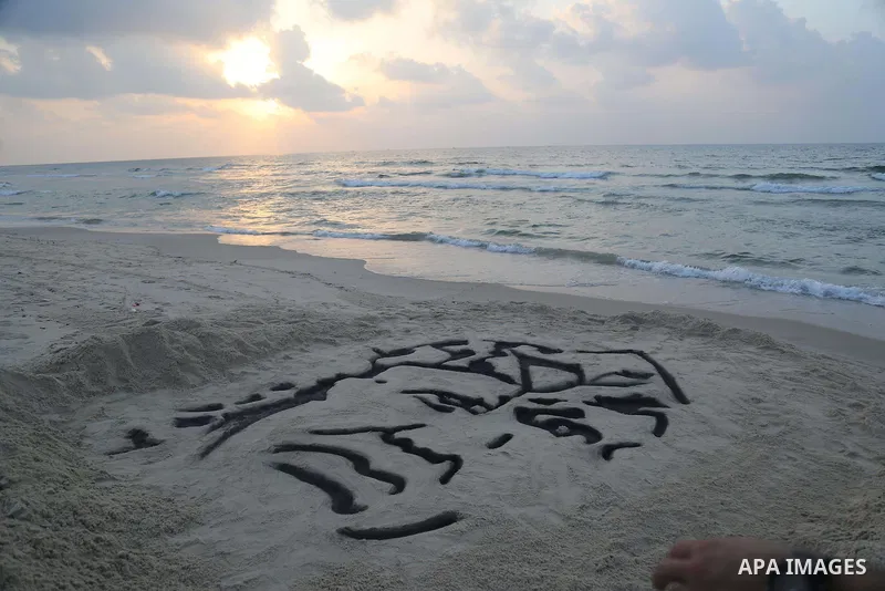 A Palestinian man creates a sand sculpture of the late Palestinian leader Yasser Arafat to mark the 11th anniversary of his death, at the beach of Gaza city, on November 10, 2015. Photo by Stringer