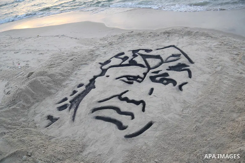 A Palestinian man creates a sand sculpture of the late Palestinian leader Yasser Arafat to mark the 11th anniversary of his death, at the beach of Gaza city, on November 10, 2015. Photo by Stringer
