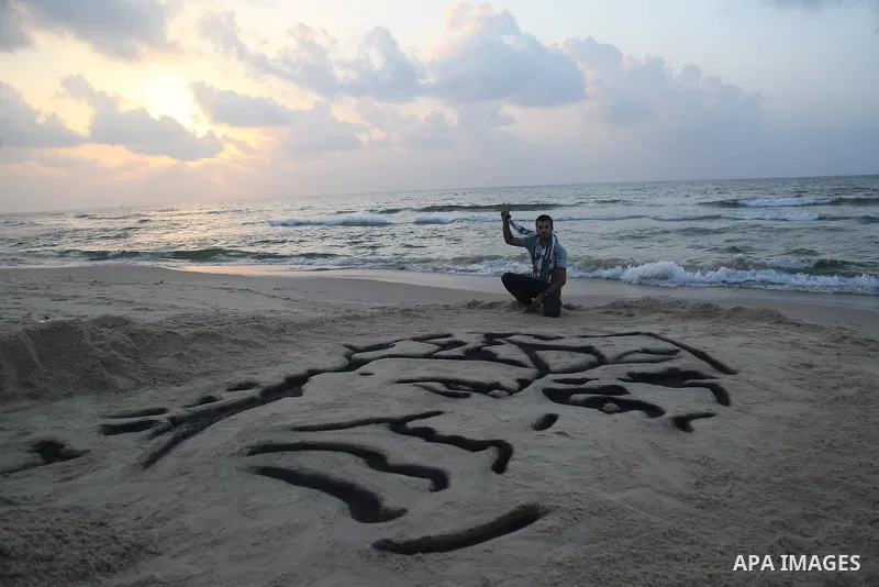 A Palestinian man creates a sand sculpture of the late Palestinian leader Yasser Arafat to mark the 11th anniversary of his death, at the beach of Gaza city, on November 10, 2015. Photo by Stringer