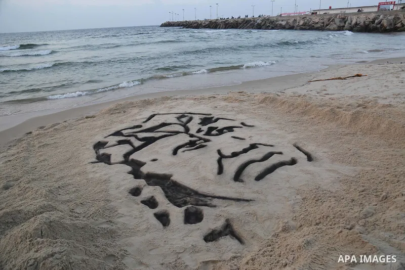 A Palestinian man creates a sand sculpture of the late Palestinian leader Yasser Arafat to mark the 11th anniversary of his death, at the beach of Gaza city, on November 10, 2015. Photo by Stringer