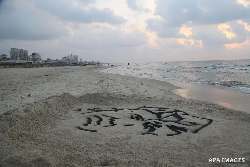 A Palestinian man creates a sand sculpture of the late Palestinian leader Yasser Arafat to mark the 11th anniversary of his death, at the beach of Gaza city, on November 10, 2015. Photo by Stringer