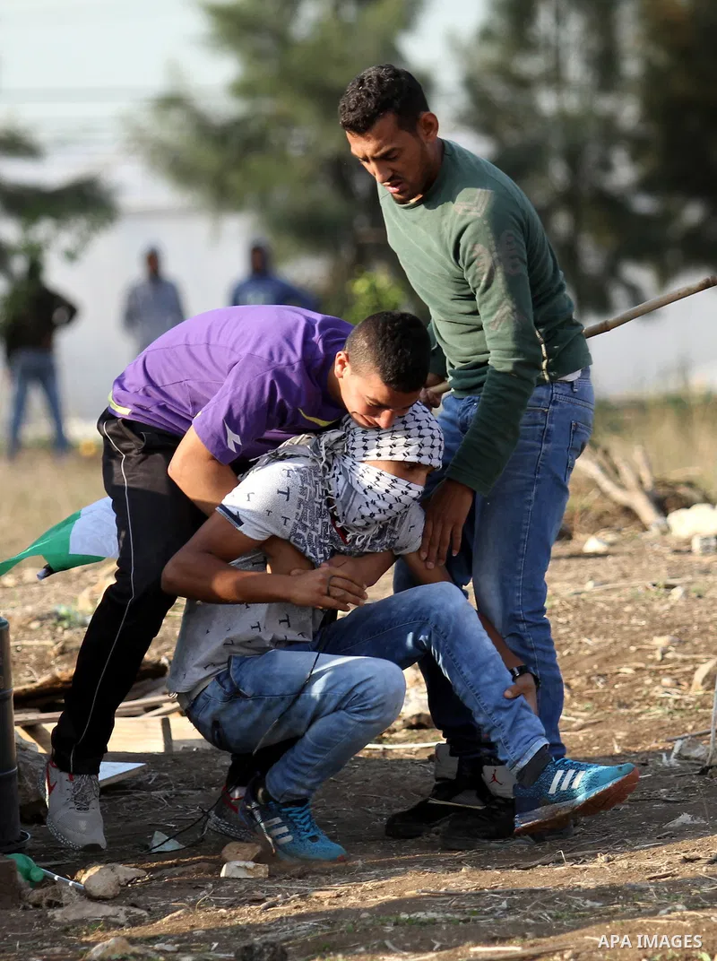 A wounded Palestinian is evacuated by protesters during clashes with Israeli security forces following a protest to mark the anniversary of the death of late Palestinian leader Yasser Arafat, in the West Bank city of Tul...