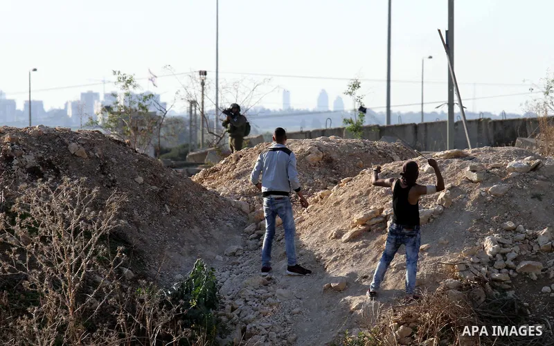 A Palestinian protester uses a sling to hurl stones at Israeli troops during clashes in the West Bank city of Tulkarm November 12, 2015. Israeli undercover forces raided a hospital in the West Bank on Thursday, shooting...