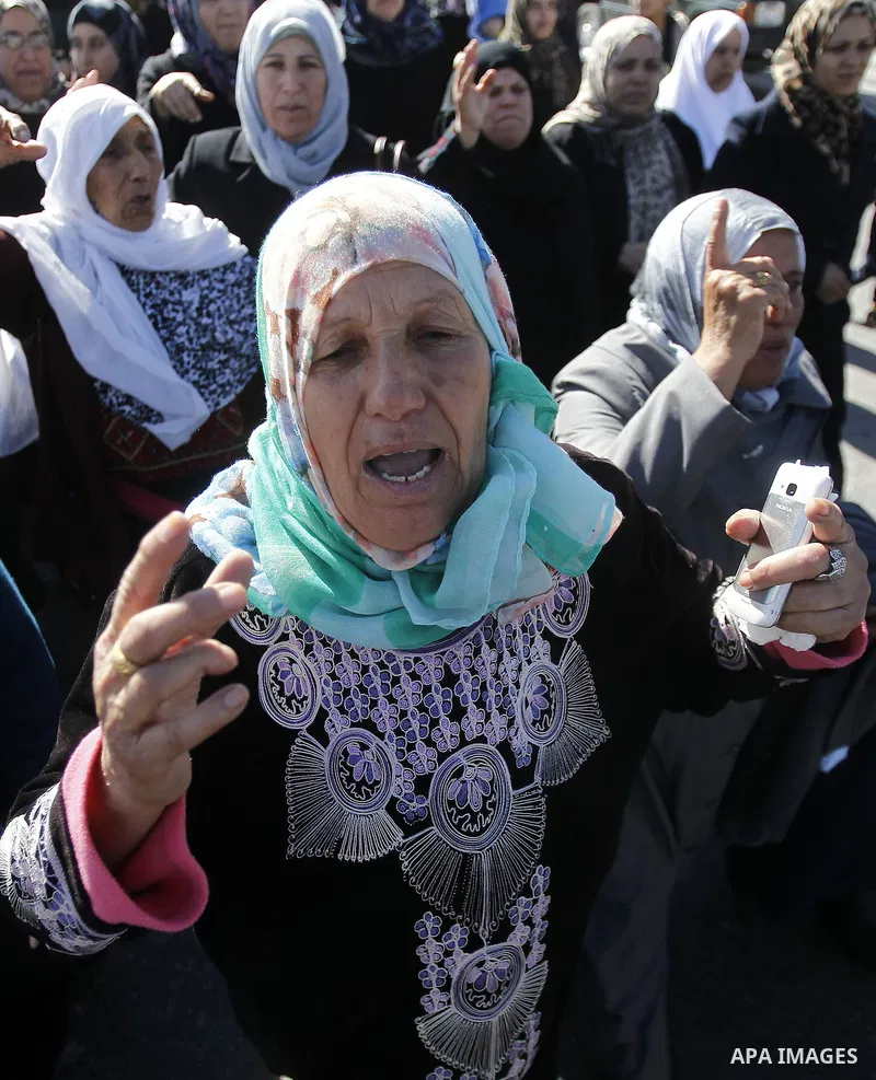 Palestinian relatives of the body of 23 year old Hassan Al-Baw, who was killed in clashes with Israeli forces, mourn during his funeral in the West Bank village of Halhul, near Hebron, Saturday, Nov. 14, 2015. Photo by W...