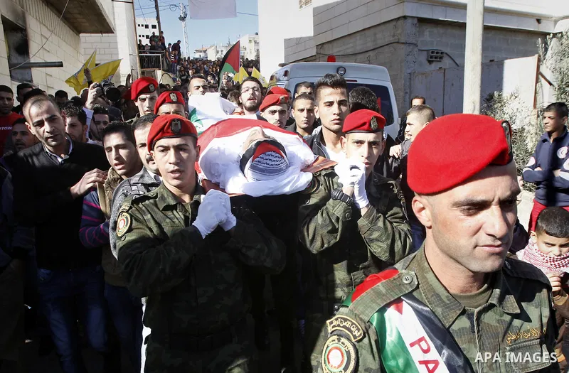 Palestinians carry the body of 23 year old Hassan Al-Baw, who was killed in clashes with Israeli forces, during his funeral in the West Bank village of Halhul, near Hebron, Saturday, Nov. 14, 2015. Photo by Wisam Hashlam...