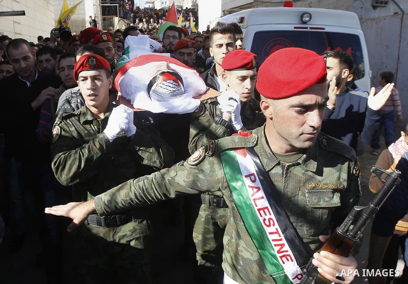 Palestinians carry the body of 23 year old Hassan Al-Baw, who was killed in clashes with Israeli forces, during his funeral in the West Bank village of Halhul, near Hebron, Saturday, Nov. 14, 2015. Photo by Wisam Hashlam...
