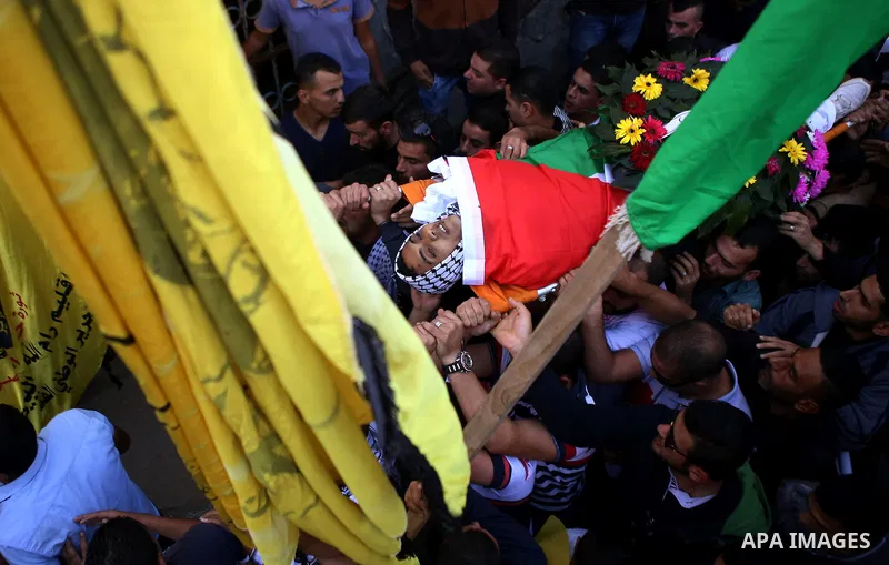 Palestinians carry the body of Lafi Awad, 22, who was killed in clashes with Israeli forces, during his funeral in the village of Budrus, near the West Bank city of Ramallah, Nov. 14, 2015. Photo by Shadi Hatem