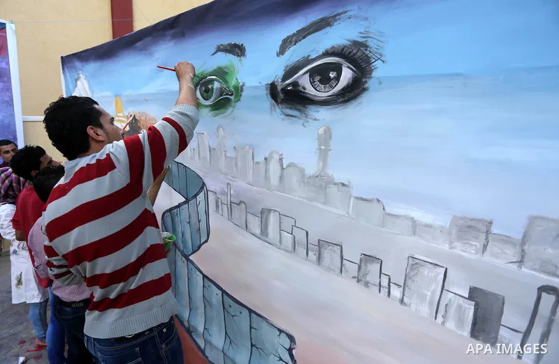 Palestinians paint murals during an event to show solidarity with the Palestinians in the West Bank and Jerusalem, in Gaza city on November 18, 2015. The surge in violence across Israel, Jerusalem and the Israeli-occupie...