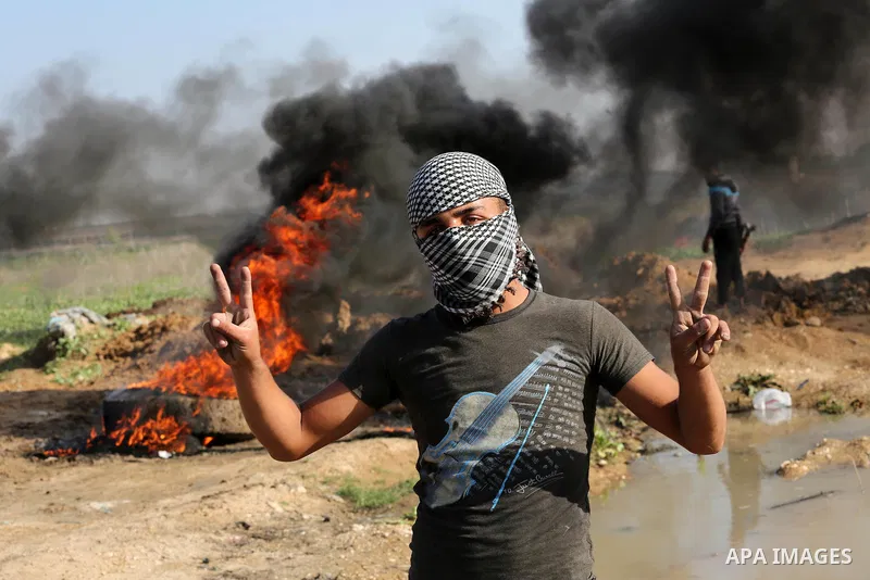 A Palestinian protester flashes victory sign during clashes with Israeli security forces near the border between Israel and eastern Gaza city, November 20, 2015. A series of attacks have been carried out by Palestinian i...