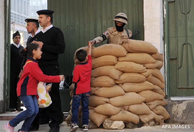Egyptian police guard the entrance to a polling station as people arrive to vote during the second round of parliamentary elections in Cairo, Egypt, November 22, 2015. Egyptians voted on Sunday in the second phase of ele...