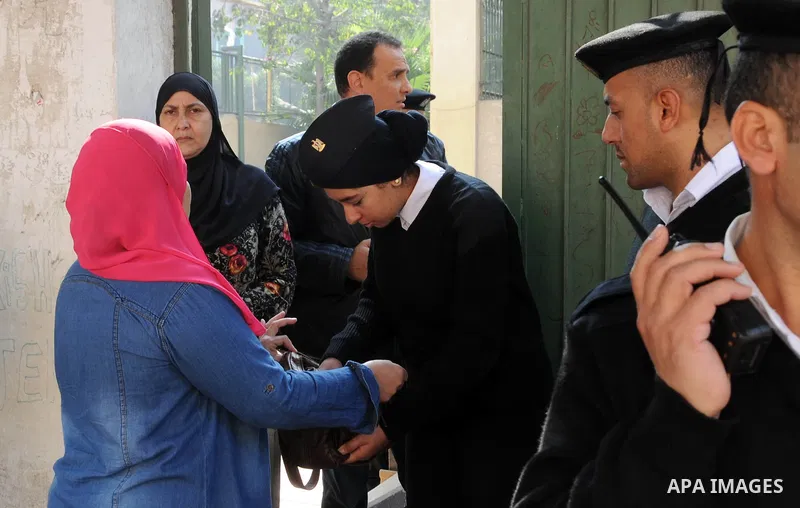 Egyptian police guard the entrance to a polling station as people arrive to vote during the second round of parliamentary elections in Cairo, Egypt, November 22, 2015. Egyptians voted on Sunday in the second phase of ele...