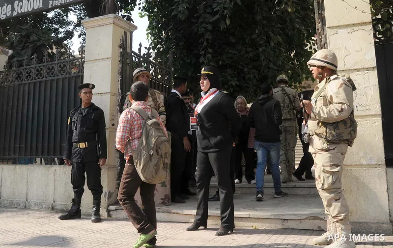 Egyptian police guard the entrance to a polling station as people arrive to vote during the second round of parliamentary elections in Cairo, Egypt, November 22, 2015. Egyptians voted on Sunday in the second phase of ele...