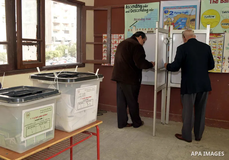 Egyptian men cast their votes at a polling station, on the second day of the final round of the country's parliamentary elections, in the capital Cairo on November 23, 2015. Egyptians are voting across 13 of the country'...