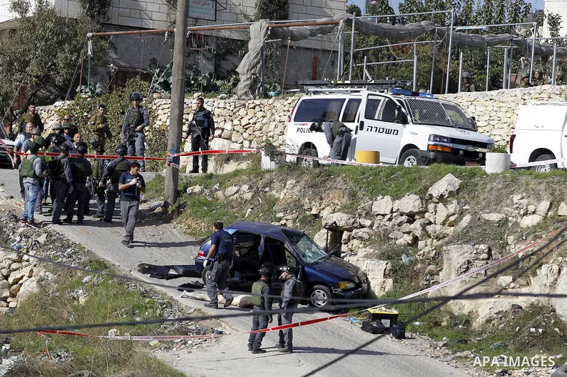 Israeli security forces inspect the body of a Palestinian man who rammed his car into Israeli soldiers injuring five of them before being shot dead, in the village of Beit Ummar, near the city of Hebron in the Israeli oc...