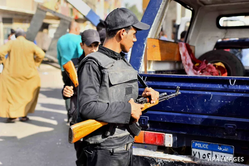 An Egyptian security member stands next to a vehicle at the site where masked gunmen on a motorcycle shot dead four Egyptian policemen south of the capital Cairo, on November 28, 2015. According to the Egyptian interior...