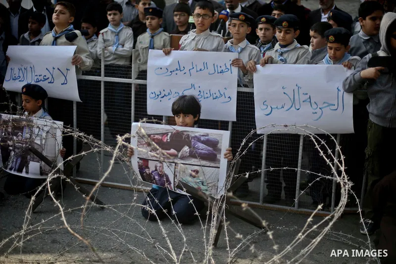Palestinian children take part in a protest demanding release the prisoners in Israeli jails, in front of high commissioner for human rights headquarters, in Gaza city, on November 29, 2015. Photo by Mohammed Talatene