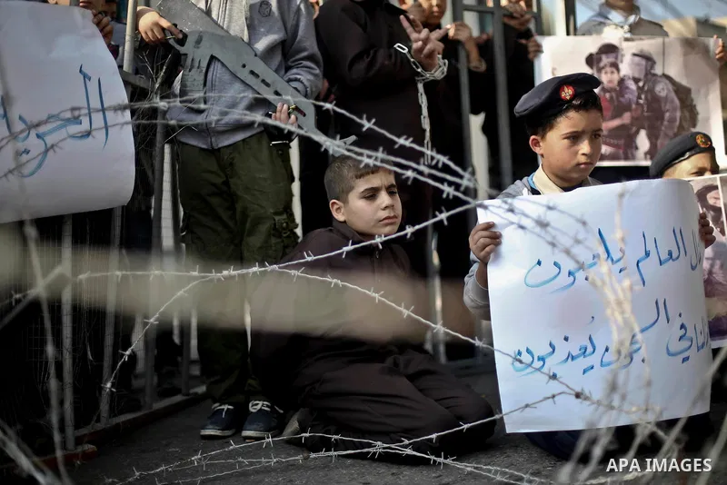 Palestinian children take part in a protest demanding release the prisoners in Israeli jails, in front of high commissioner for human rights headquarters, in Gaza city, on November 29, 2015. Photo by Mohammed Talatene
