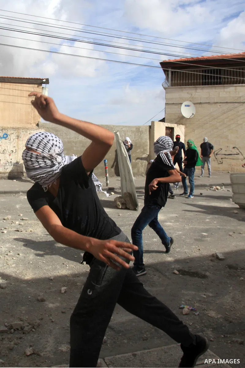 Palestinian protesters take part in clashes with Israeli security forces in Ras al-Amoud neighborhood, in Jerusalem against the killing of Palestinian teenager Ayman al-Abbasi on November 30, 2015. A 17-year-old Palestin...