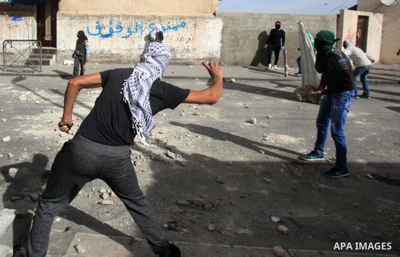 Palestinian protesters take part in clashes with Israeli security forces in Ras al-Amoud neighborhood, in Jerusalem against the killing of Palestinian teenager Ayman al-Abbasi on November 30, 2015. A 17-year-old Palestin...