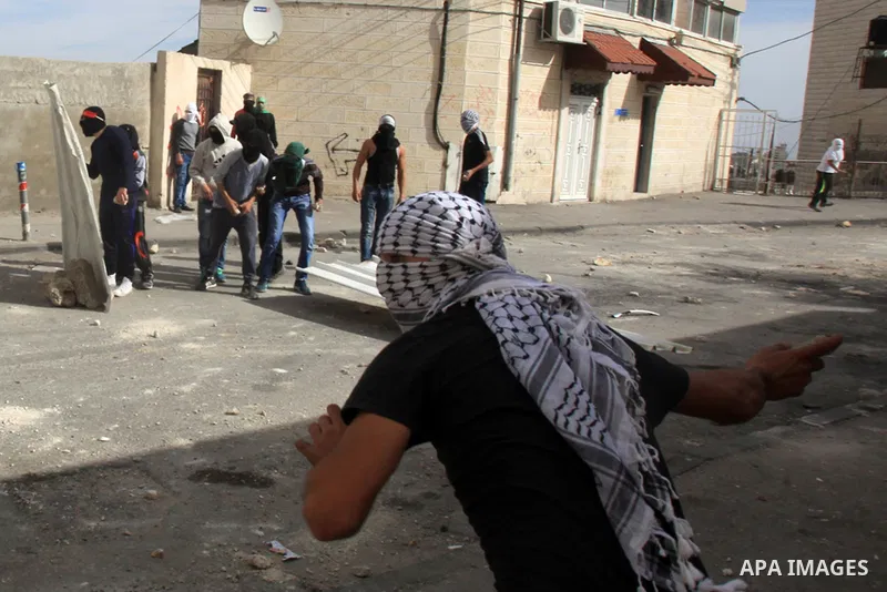 Palestinian protesters take part in clashes with Israeli security forces in Ras al-Amoud neighborhood, in Jerusalem against the killing of Palestinian teenager Ayman al-Abbasi on November 30, 2015. A 17-year-old Palestin...
