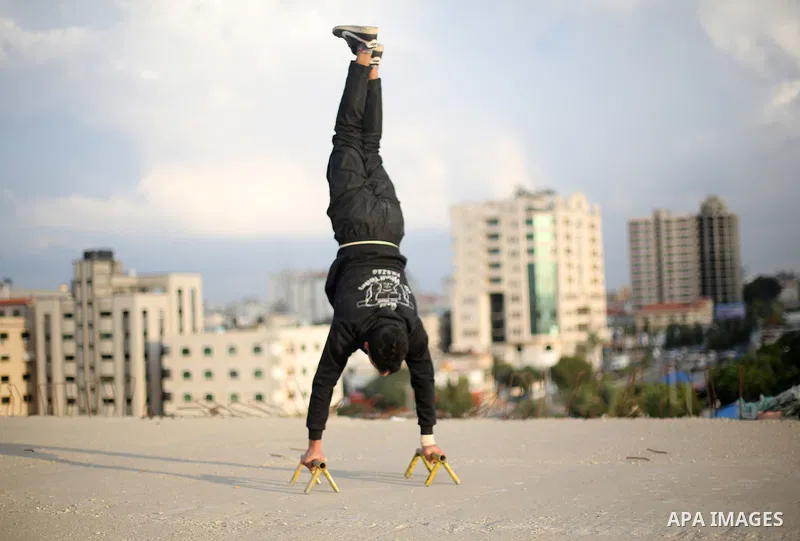 A member of "Bar Woolf," a street workout team practices his skills during a training session in Gaza City on November 30, 2015. Self-taught daredevils in the blockaded Gaza Strip are embracing a range of extreme sports,...