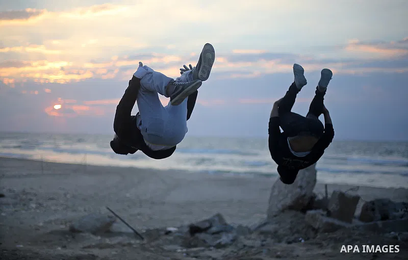 Member of "Bar Woolf," a street workout team practice their skills during a training session in Gaza City on November 30, 2015. Self-taught daredevils in the blockaded Gaza Strip are embracing a range of extreme sports,...