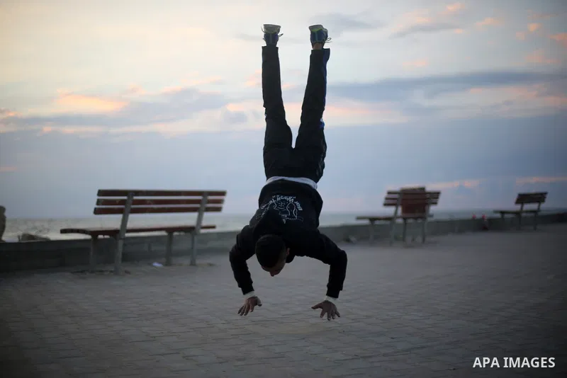 A member of "Bar Woolf," a street workout team practices his skills during a training session in Gaza City on November 30, 2015. Self-taught daredevils in the blockaded Gaza Strip are embracing a range of extreme sports,...