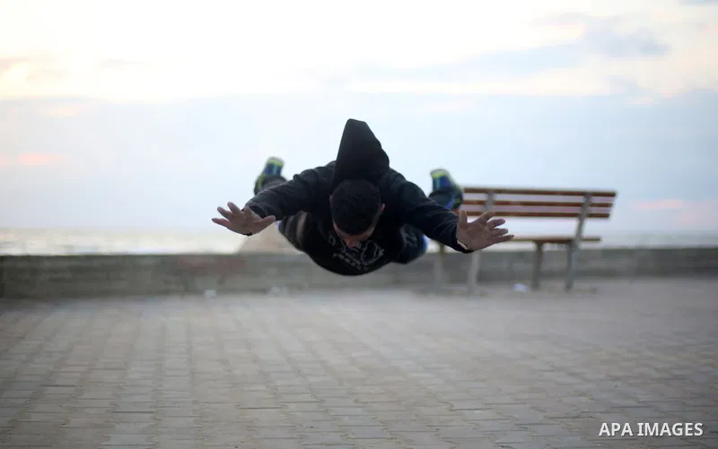 A member of "Bar Woolf," a street workout team practices his skills during a training session in Gaza City on November 30, 2015. Self-taught daredevils in the blockaded Gaza Strip are embracing a range of extreme sports,...