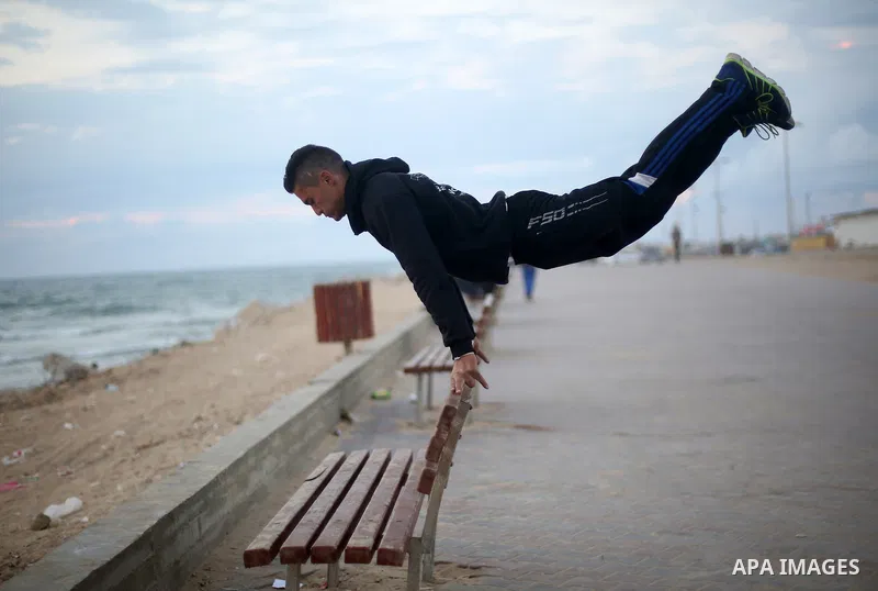 A member of "Bar Woolf," a street workout team practices his skills during a training session in Gaza City on November 30, 2015. Self-taught daredevils in the blockaded Gaza Strip are embracing a range of extreme sports,...