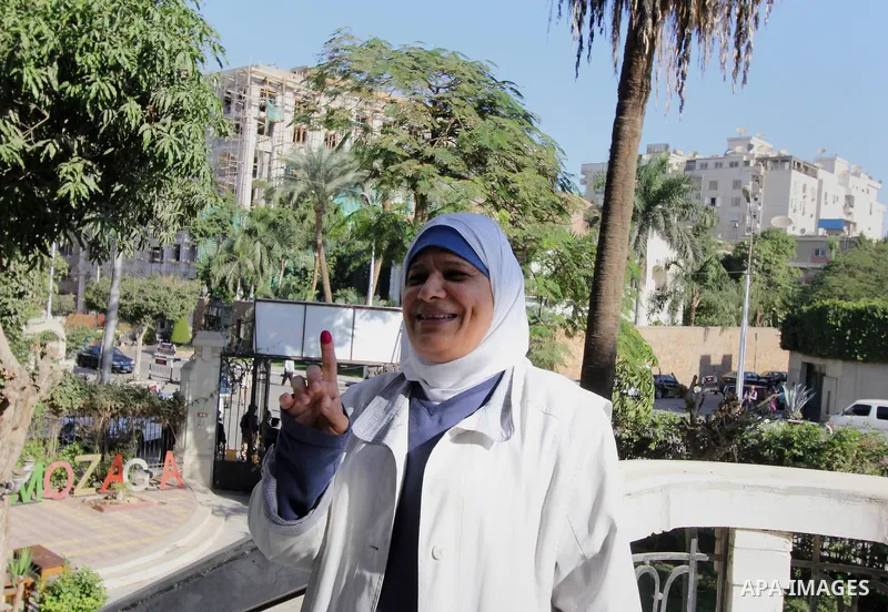 An Egyptian woman casts her ballot at a polling station during the run-off in the second phase of Egypt's parliamentary elections in Shibin El-Kom in the Menufiya province, 60 kilometers north of the capital Cairo, on De...