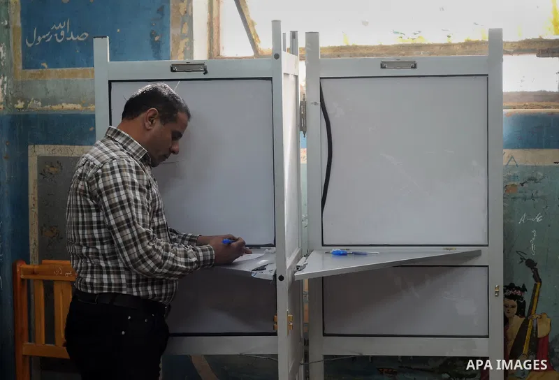 An Egyptian man casts his ballot at a polling station during the run-off in the second phase of Egypt's parliamentary elections in Shibin El-Kom in the Menufiya province, 60 kilometers north of the capital Cairo, on Dece...
