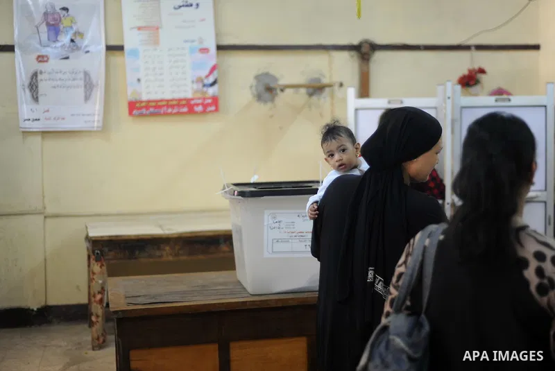 Egyptians cast their ballot at a polling station during the run-off in the second phase of Egypt's parliamentary elections in Shibin El-Kom in the Menufiya province, 60 kilometers north of the capital Cairo, on December...
