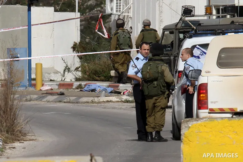 Israeli security forces check the body of a young Palestinian woman who was shot dead after reportedly seeking to stab a soldier at the Einav checkpoint, east of Tulkarem in the occupied West Bank, on December 1, 2015. P...