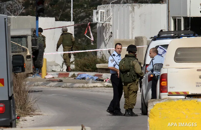 Israeli security forces check the body of a young Palestinian woman who was shot dead after reportedly seeking to stab a soldier at the Einav checkpoint, east of Tulkarem in the occupied West Bank, on December 1, 2015. P...