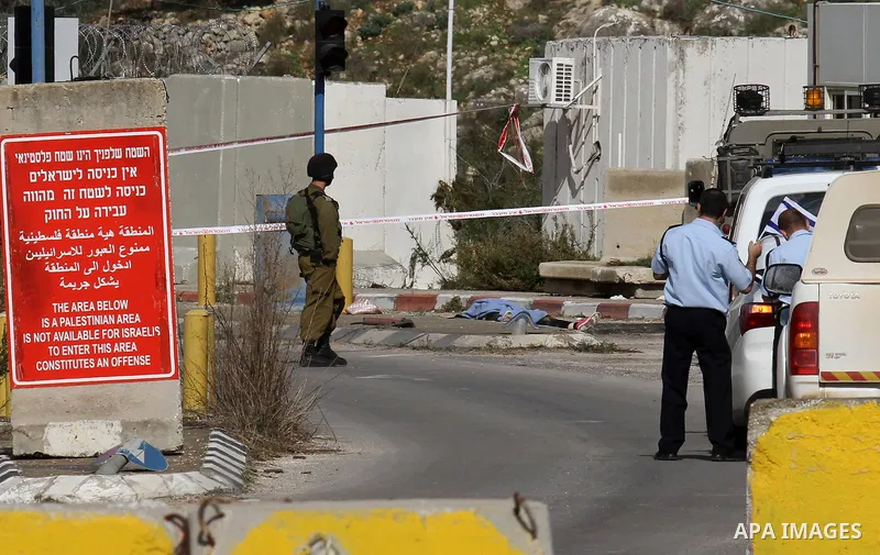 Israeli security forces check the body of a young Palestinian woman who was shot dead after reportedly seeking to stab a soldier at the Einav checkpoint, east of Tulkarem in the occupied West Bank, on December 1, 2015. P...