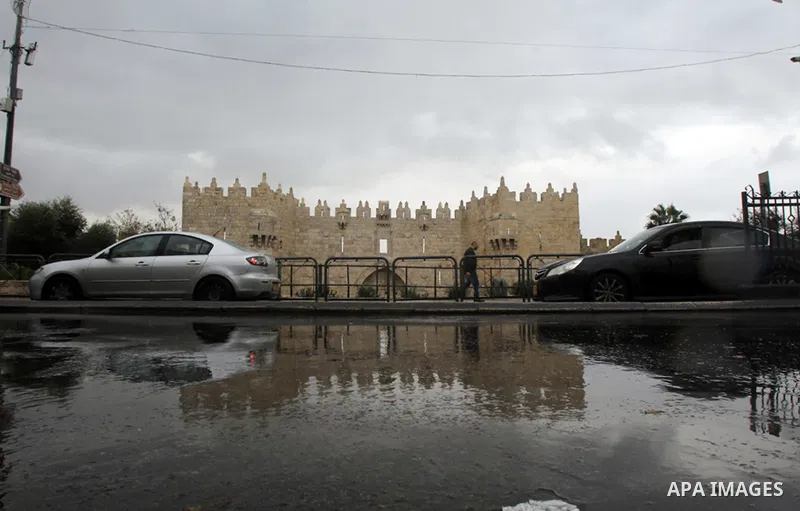 Palestinians walk in front of Damascus gate during a rainy day at the al-Aqsa mosque compound, in Jerusalem's old city on December 01, 2015. Photo by Mahfouz Abu Turk
